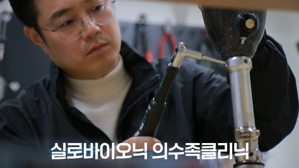 A technician adjusting the connecting components of a prosthetic leg